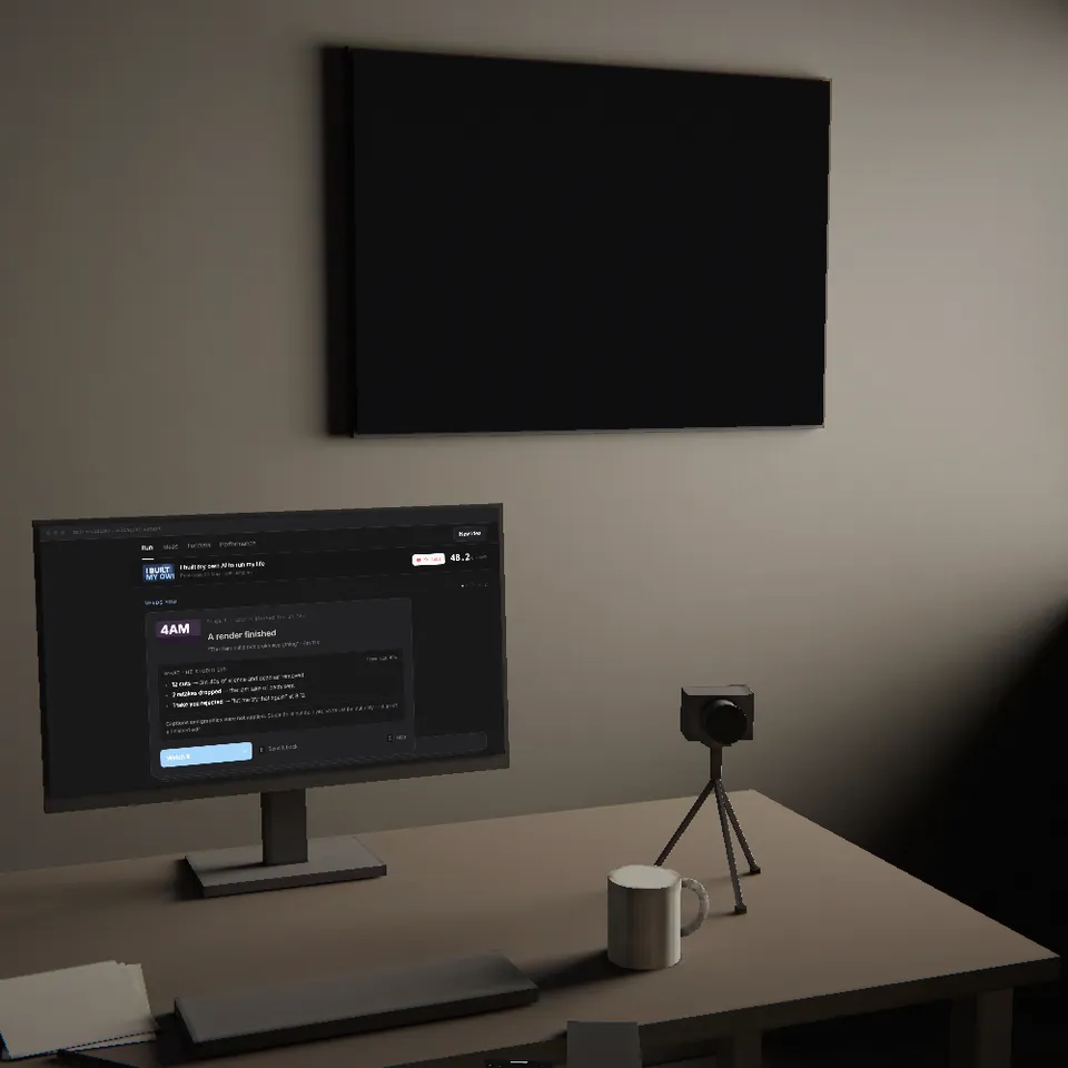 The same desk in the morning: monitor, camera on its tripod, a mug, daylight in the window.